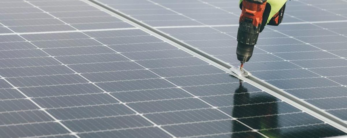 Technician installing a utility-scale solar panel array